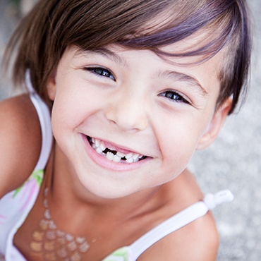 Smiling girl with missing front teeth