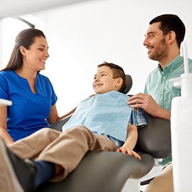 Father and son talking with dental team member