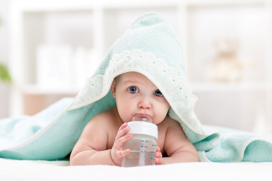 A baby drinking a bottle of water.